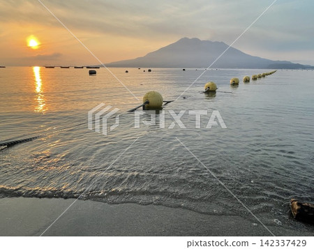 晨曦灑在大海和櫻島火山上。 晨曦灑在大海和櫻島火山上。 142337429