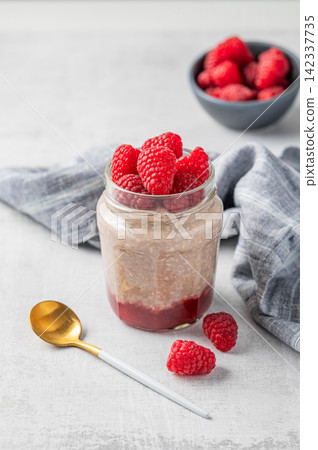 Oatmeal in a jar with raspberries overnight in alternative milk on a light background Oatmeal in a jar with raspberries overnight in alternative milk on a light background 142337735