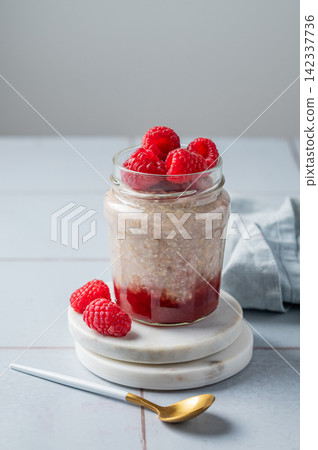 Oatmeal in a jar with raspberries overnight in alternative milk on a light background Oatmeal in a jar with raspberries overnight in alternative milk on a light background 142337736