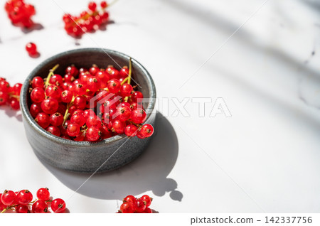 Fresh Red Currants in Ceramic Bowl on Marble Background in Warm Sunlight Fresh Red Currants in Ceramic Bowl on Marble Background in Warm Sunlight 142337756