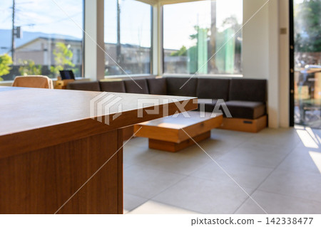 A spacious living room, with light streaming in through the large windows. A spacious living room, with light streaming in through the large windows. 142338477