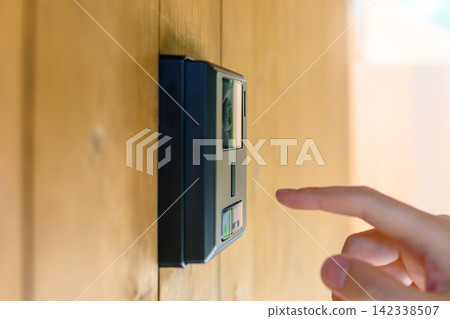 A finger presses the doorbell button. A finger presses the doorbell button. 142338507