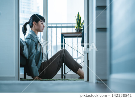 一個想要擺脫西裝束縛的女人，在房間裡低下了頭。 142338841