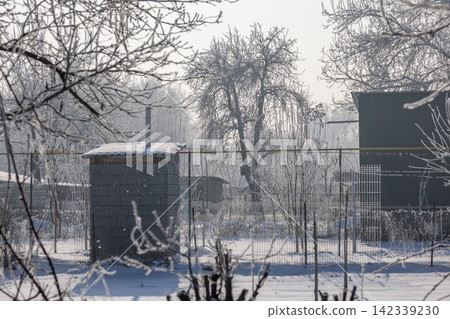 Frosty Winter Backyard with Outhouse and Green Building Frosty Winter Backyard with Outhouse and Green Building 142339230