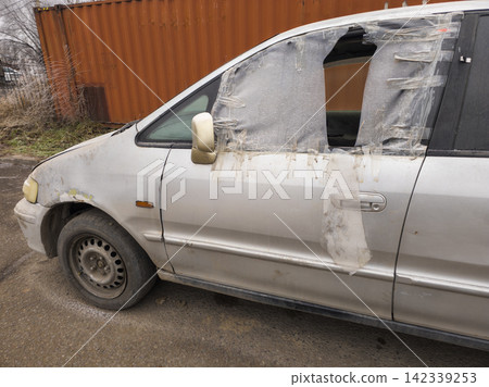 Damaged Silver Minivan with Plastic Covered Windows Damaged Silver Minivan with Plastic Covered Windows 142339253
