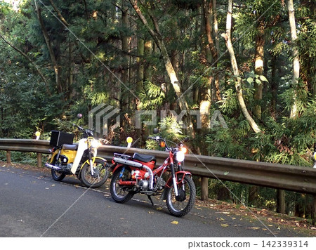 Two Honda Cubs riding through the mountains Two Honda Cubs riding through the mountains 142339314