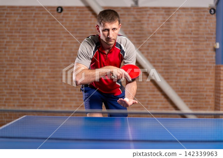 Male athlete holding paddle and ball before serving Male athlete holding paddle and ball before serving 142339963