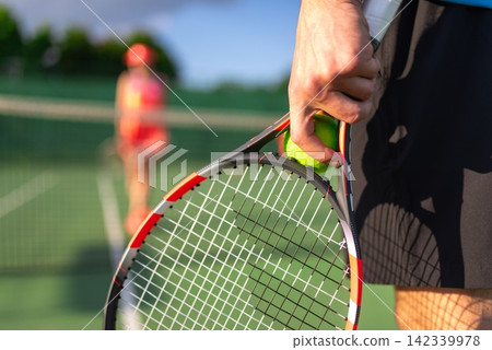 Hand holding a tennis racket and ball ready for service Hand holding a tennis racket and ball ready for service 142339978