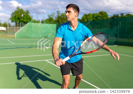 Man executing a powerful forehand swing on court Man executing a powerful forehand swing on court 142339979