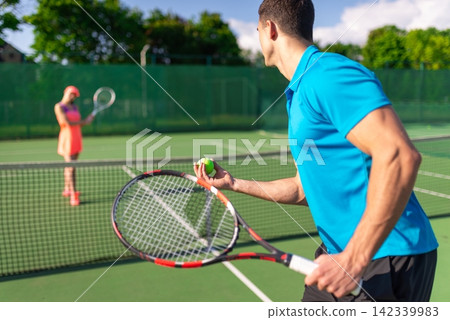 Tennis player preparing to serve the ball Tennis player preparing to serve the ball 142339983