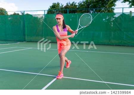 A tennis player woman preparing for a backhand stroke A tennis player woman preparing for a backhand stroke 142339984