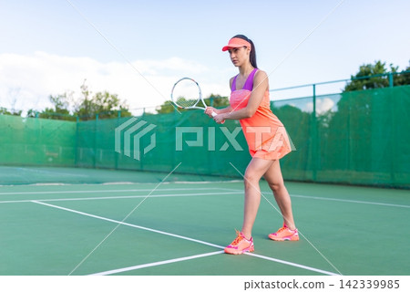 A tennis player woman preparing for a backhand stroke A tennis player woman preparing for a backhand stroke 142339985