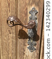 Close up macro shot of a vintage handcrafted metal door handle and lock on a traditional rustic wooden door in Hausham, Upper Bavaria, Germany. 142340299