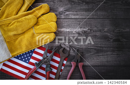American Labor Day Concept with the flag of America and working tools on wooden background American Labor Day Concept with the flag of America and working tools on wooden background 142340584