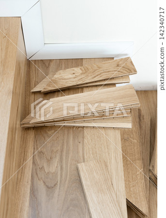Oak parquet planks on a wooden staircase during herringbone hardwood flooring installation Oak parquet planks on a wooden staircase during herringbone hardwood flooring installation 142340717