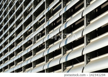 Modern building facade with repeating louvers and metallic texture Modern building facade with repeating louvers and metallic texture 142341294
