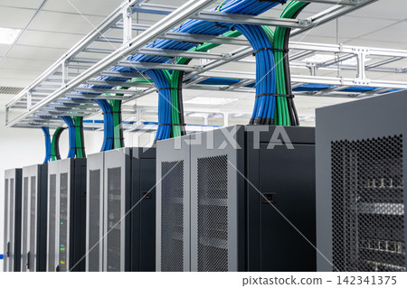 Organized server racks with neatly managed blue and green cables in a data center Organized server racks with neatly managed blue and green cables in a data center 142341375