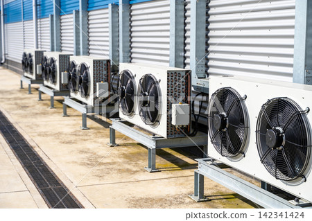 Outdoor air conditioning units lined up on a rooftop with corrugated metal wall Outdoor air conditioning units lined up on a rooftop with corrugated metal wall 142341424