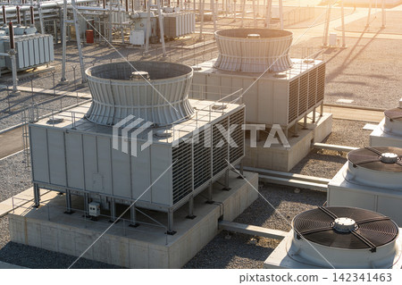 Industrial cooling towers and HVAC units on a rooftop with electrical transformers Industrial cooling towers and HVAC units on a rooftop with electrical transformers 142341463