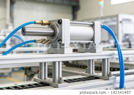 Industrial pneumatic cylinder with blue hoses on a factory conveyor system Industrial pneumatic cylinder with blue hoses on a factory conveyor system 142341497