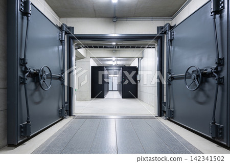 Massive vault doors open to reveal a modern server room with rows of black cabinets Massive vault doors open to reveal a modern server room with rows of black cabinets 142341502