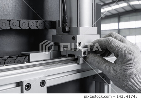 Close-up of gloved hands adjusting industrial machinery with precision components Close-up of gloved hands adjusting industrial machinery with precision components 142341745
