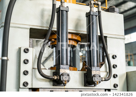 Heavy duty industrial hydraulic cylinders and machinery components in a factory setting 142341826