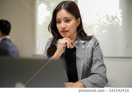 Employee analyzing business data on laptop during remote office work for corporate presentations and marketing materials Employee analyzing business data on laptop during remote office work for corporate presentations and marketing materials 142342410