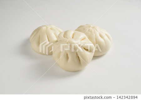 Soft steamed bao buns with pleated tops on white background Soft steamed bao buns with pleated tops on white background 142342894