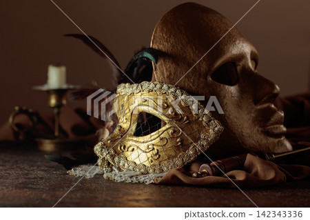 Golden carnival masks on a brown background. Golden carnival masks on a brown background. 142343336