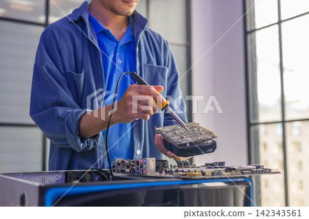 A computer technician repairing or assembling a desktop computer. A computer technician repairing or assembling a desktop computer. 142343561