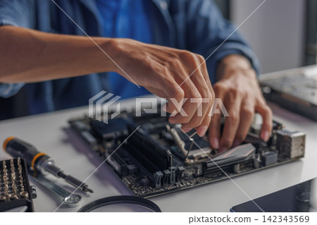 Professional technician or engineer repairing or assembling electronic computer PC equipment. Professional technician or engineer repairing or assembling electronic computer PC equipment. 142343569