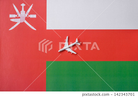 An airplane on the Omani flag as a conceptual backdrop for travel. An airplane on the Omani flag 142343701
