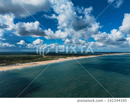 High angle wide horizontal aerial drone photograph of North Sea beach coastline, sand dunes, sea water, and cloudy blue sky at Neeltje Jans, Zeeland, Netherlands on sunny summer day High angle wide horizontal aerial drone photograph of North Sea beach coastline, sand dunes, sea water, and cloudy blue sky at Neeltje Jans, Zeeland, Netherlands on sunny summer day 142344395
