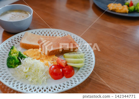 A Western-style breakfast plate and soup placed on a wooden table. A Western-style breakfast plate and soup placed on a wooden table. 142344771