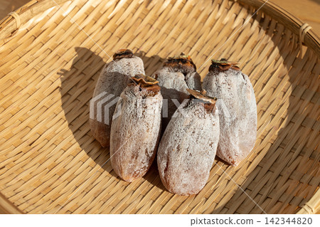 Dried persimmons (koro-gaki) covered in white powder, placed on a sieve; persimmon frost; December 142344820