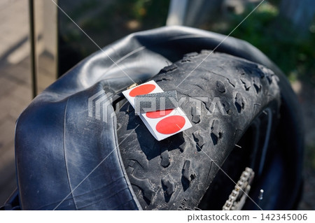 Bicycle puncture repair kit resting on a fat bike rubber tire 142345006