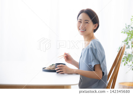 一位女士正在吃蕎麥麵 一位女士正在吃蕎麥麵 142345680
