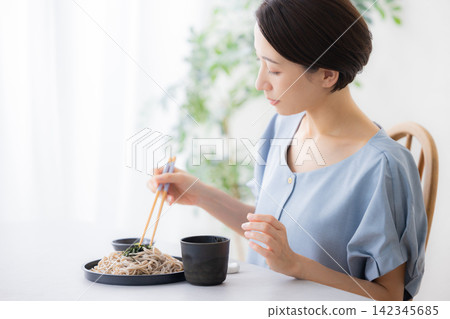 A woman eating soba noodles A woman eating soba noodles 142345685