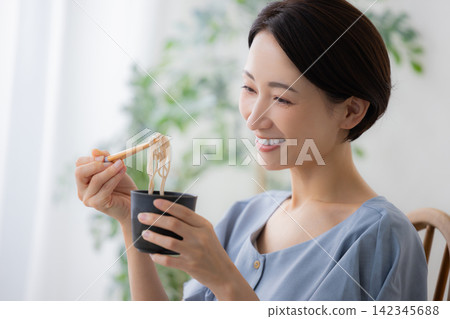 一位女士正在吃蕎麥麵 一位女士正在吃蕎麥麵 142345688