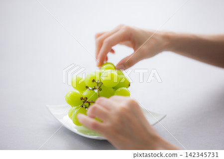 A woman holding Shine Muscat grapes A woman holding Shine Muscat grapes 142345731