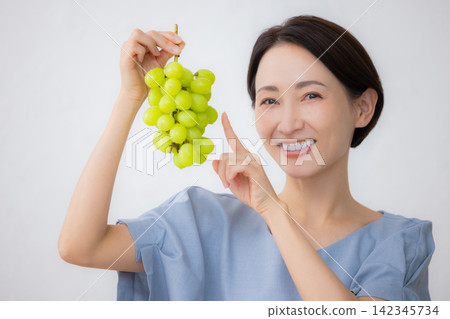 A woman holding Shine Muscat grapes A woman holding Shine Muscat grapes 142345734