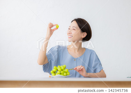 A woman holding Shine Muscat grapes A woman holding Shine Muscat grapes 142345736