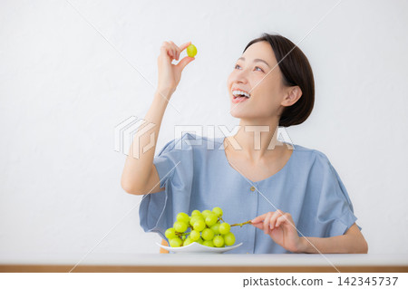 A woman holding Shine Muscat grapes A woman holding Shine Muscat grapes 142345737