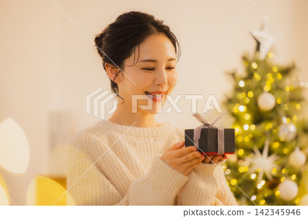 A young woman giving a Christmas present A young woman giving a Christmas present 142345946