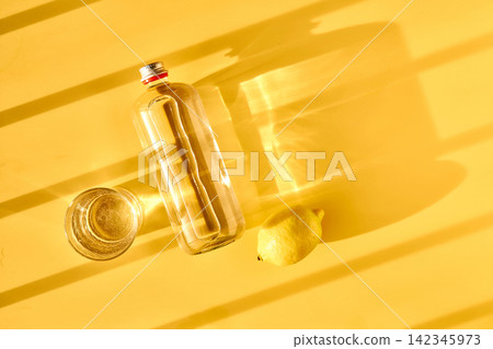 Staying hydrated with water, glass bottle, and lemon 142345973