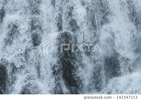 Close-up of the water flow and spray of Oshinkoshin Falls in Shari Town, Hokkaido, Japan. Close-up of the water flow and spray of Oshinkoshin Falls in Shari Town, Hokkaido, Japan. 142347153