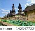 A landscape of traditional multi-tiered pagodas and lotus ponds standing in front of the Taman Ayun Temple, a World Heritage Site in Bali. 142347722