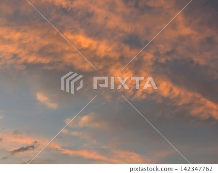 夕陽西下,橘色的雲朵籠罩著天空。 夕陽西下,橘色的雲朵籠罩著天空。 142347762