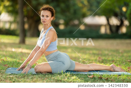 Adult woman doing yoga in pigeon pose Adult woman doing yoga in pigeon pose 142348330